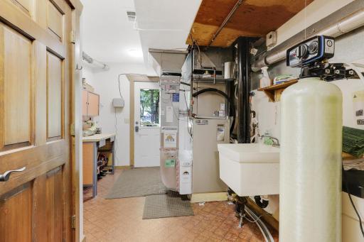 Utility room with workshop area, sink and access to yard.