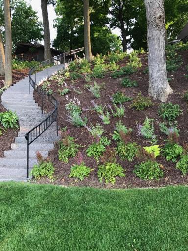 Beautiful landscaping and stairs going up to home.