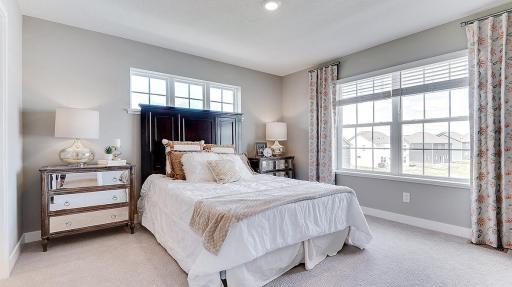 Large primary suite with plenty of light and windows. Model shown. Colors and finishes may vary.