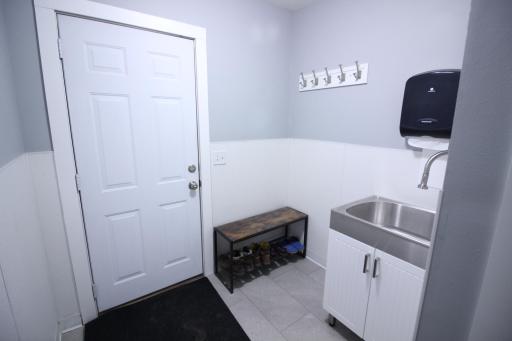 Large 10'6" x 6'9" new mudroom. Door accesses the garage. There is a large stainless steel utility sink to wash up after your fun outside. Easy to maintain vinyl plank flooring and the lower walls are covered with fiberglass panels for easy cleaning.