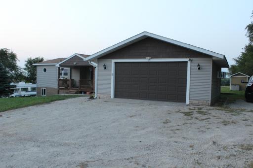 Large 24 x 24 garage with an 8' high garage door so your large truck fits inside. Extra parking on east side of garage or you can drive around to the back of the 1 acre lot.