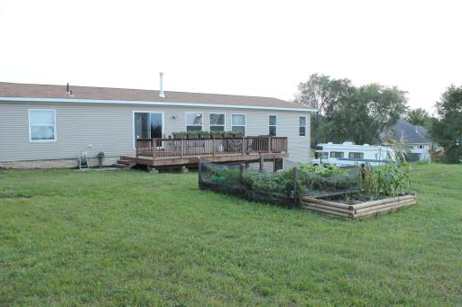 Northside, back of the home with 2020 built 12' x 28' deck. Built with the same low maintenance cedar tone wood. Room for a large group to party or add a gate by the steps and it becomes a very large play pen for a little one. Also raised garden beds