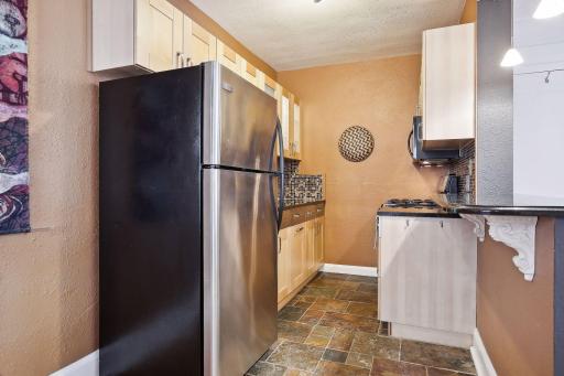 Renovated kitchen with stainless appliances, granite countertops, slate floor, backsplash and beautiful cabinetry.
