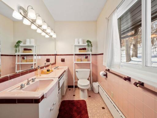 Full bathroom with double sinks, freshly painted and tons of character with the vintage pink