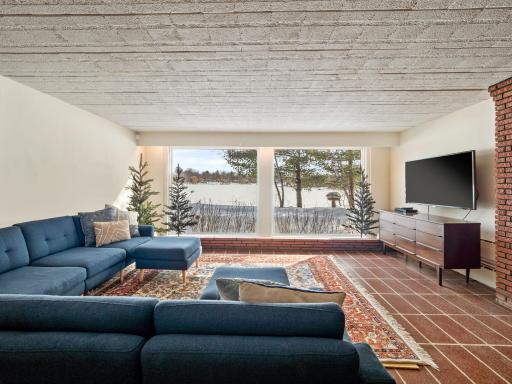 Lower level family room has floor to ceiling windows to enjoy all of the views in the private backyard
