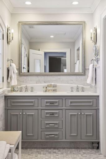 A double vanity with gorgeous hardware selections, custom cabinetry and beautiful lighting!