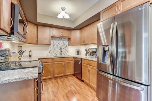 Fantastic kitchen with newer stainless steel appliances, sparkling granite countertops, pantry closet, breakfast bar seating and gorgeous wood floors that extend to the adjacent informal dining space.