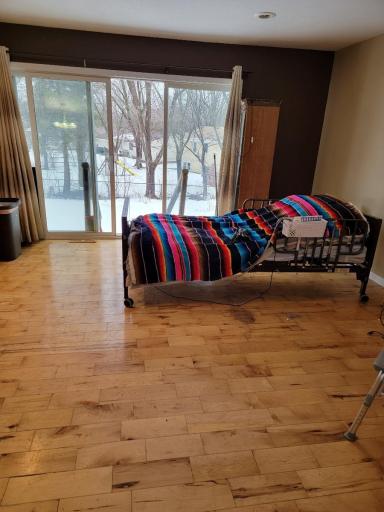 Ultimately, it's important to focus on the positives of the living room, such as the beautiful hardwood floors, wood burning firplace and the stunning views, and not let the hospital bed detract from the overall beauty of the space.