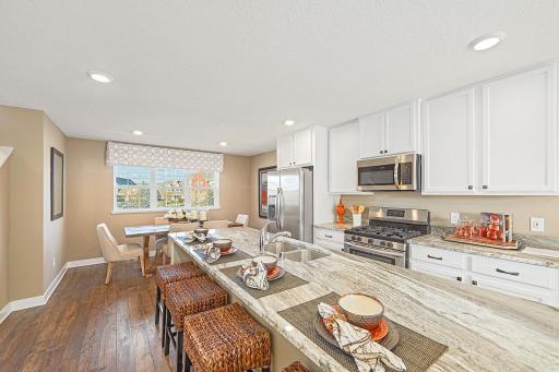 Oversized granite island in the kitchen never disappoints! Photos from previous model home, finishes and options to vary.