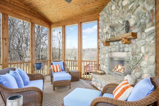 This Minnesota must-have screen porch with a wood-burning fireplace is located in the back of the house, just off the kitchen.