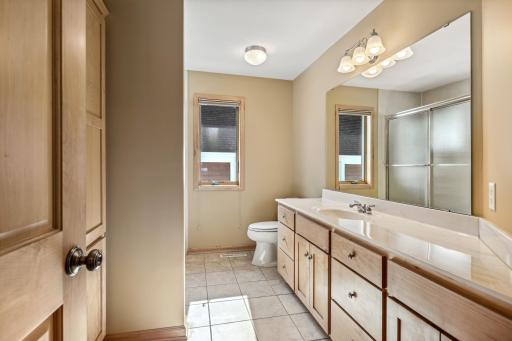 Upper level full bath boasts an oversized vanity, double linen closet, tub/shower with ceramic tile.