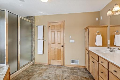 A separate walk-in shower, spacious linen closet, double vanity with Quartz countertops and separate commode room with window complete this luxurious bath.