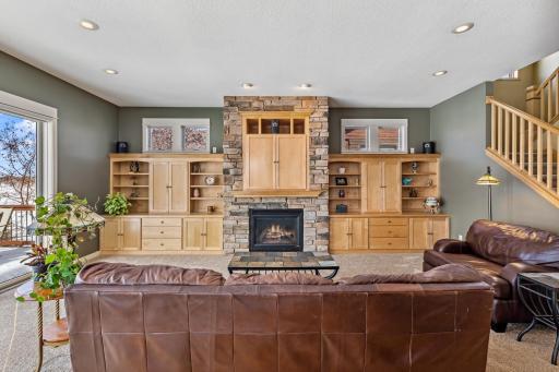 Curl up in the great room and take in the beauty of the lake while soaking in the ambiance of the gas fireplace. Custom cabinetry flanks the stack stone fireplace with room for all your media equipment.