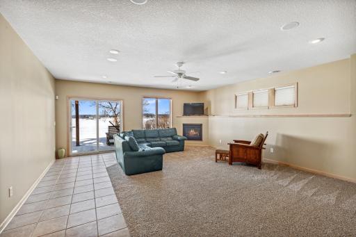 A spacious amusement room overlooks the lake with access to the picturesque setting beyond.