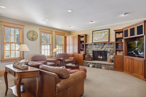 The cozy family room with wood burning fireplace and built in book shelves and TV cabinet is perfectly placed right next to the kitchen and main floor library/office