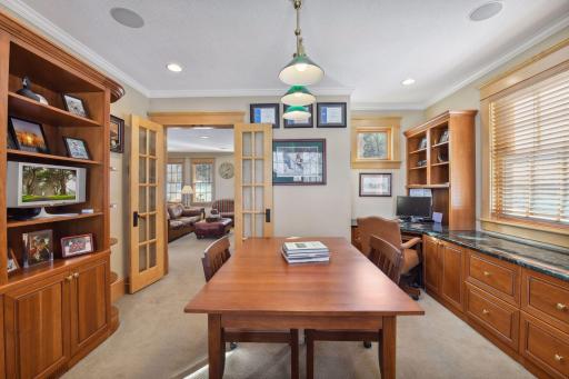 Main level office with corner windows and built ins offers a perfect work from home option