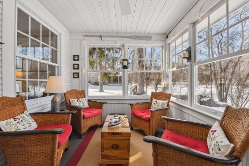 Evening gatherings often involve conversation and a glass of wine nestled on this charming porch