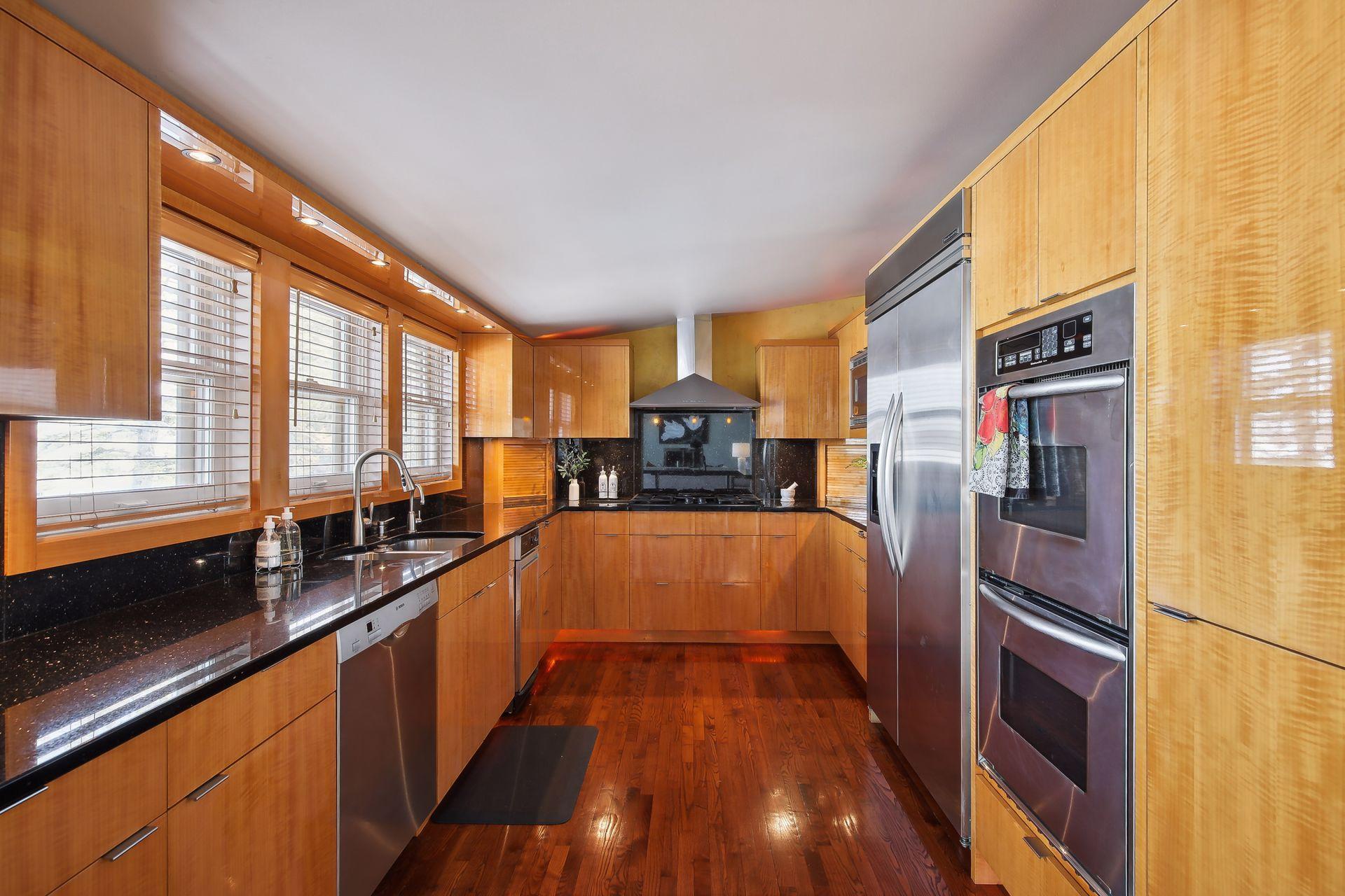 Modern and sleek kitchen design with high-end appliances, including double wall ovens and gas cooktop