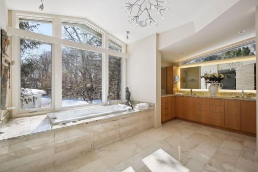 Spa-like bath with heated floors, jetted tub, large walk-in shower, dual sinks and wooded views