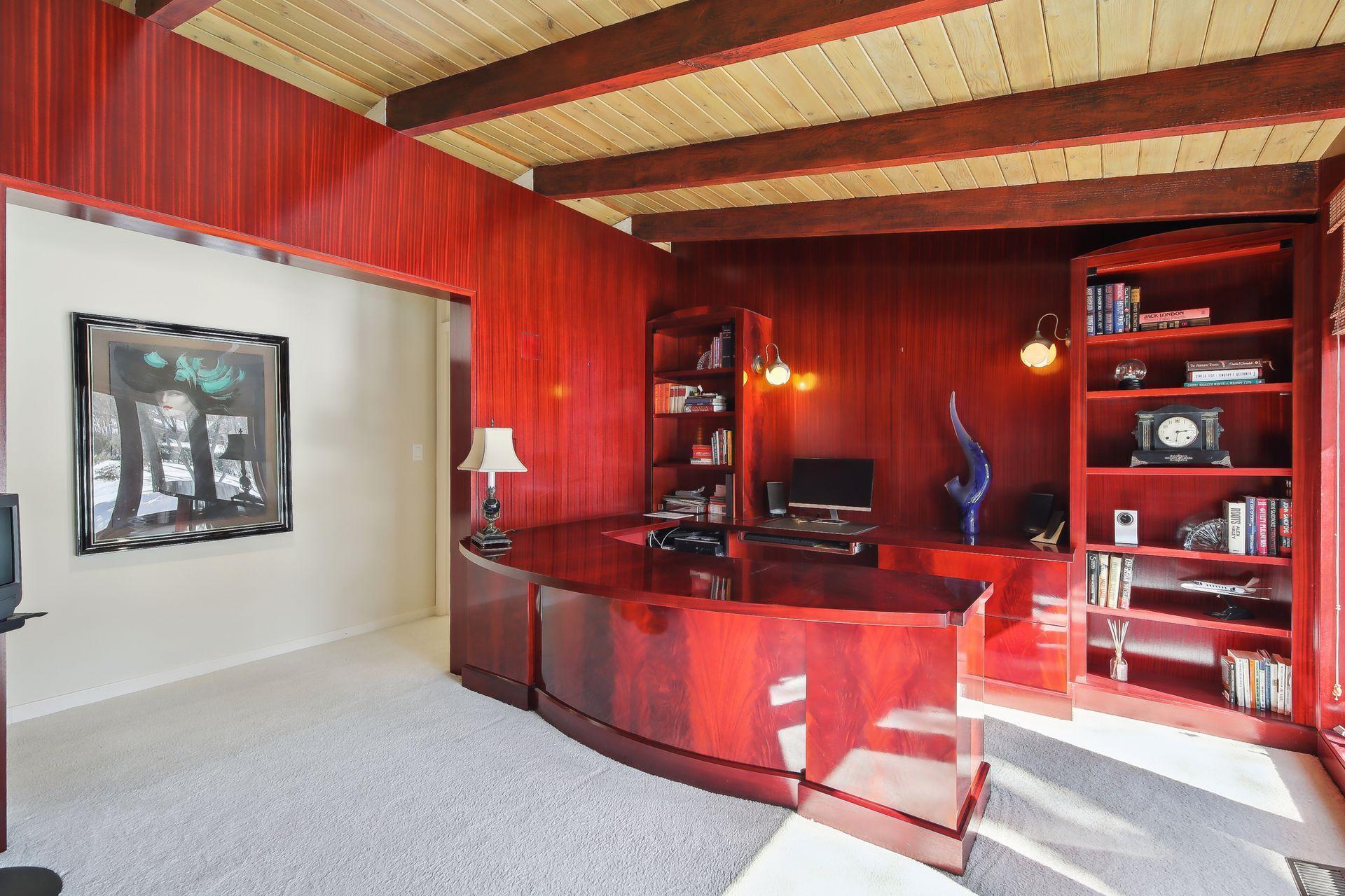 Main floor offers a dedicated home office space complete with gorgeous woodwork, built-in cabinets and desk, and floor to ceiling windows overlooking the front yard