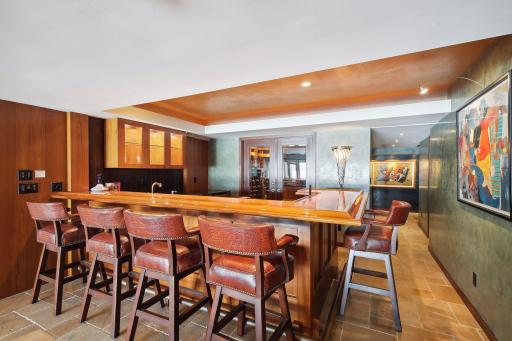 A fun place to gather, the lower level bar features sink, ice maker, dishwasher and beverage refrigerator