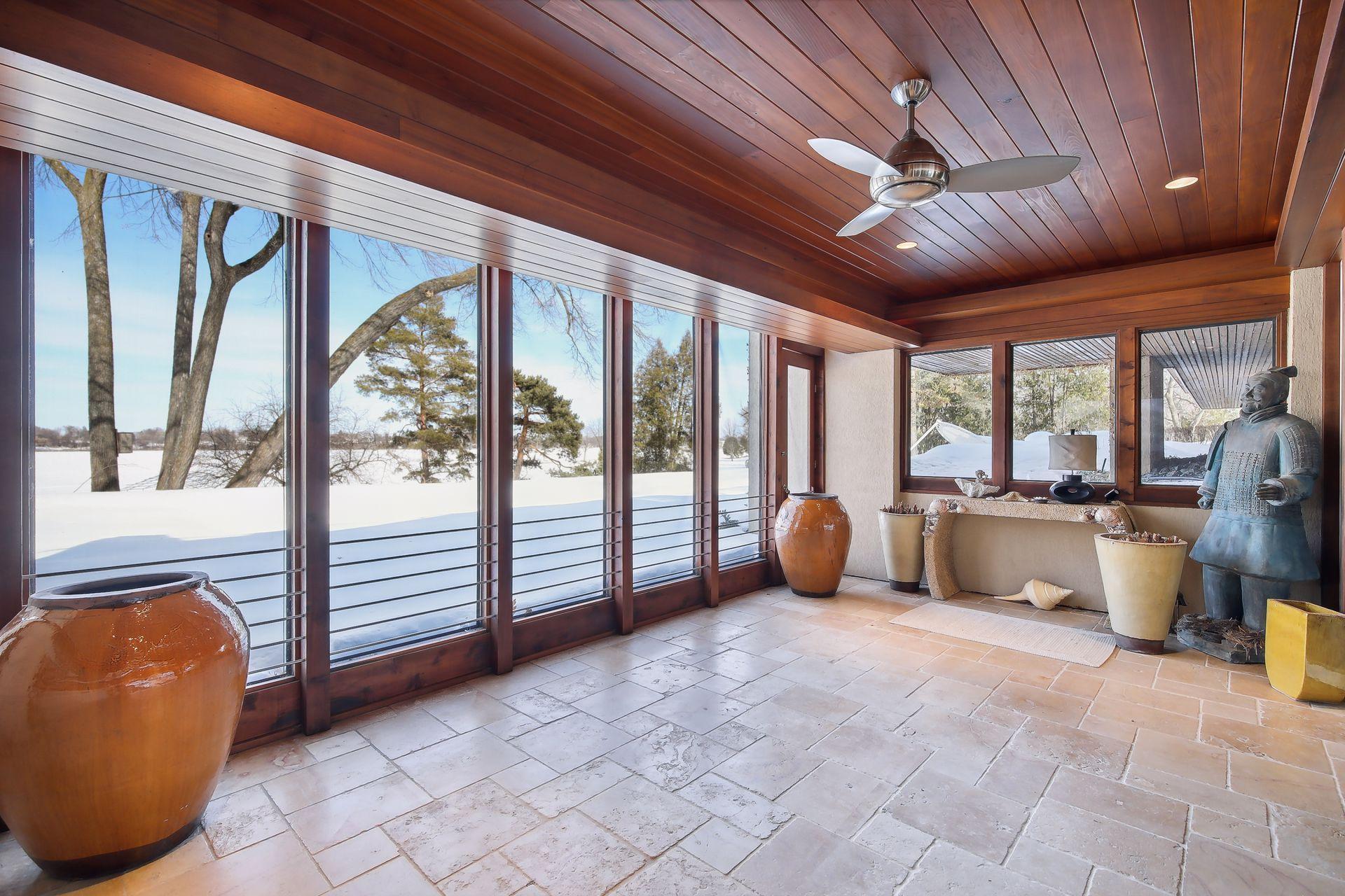 Lower level sun room with access to the pool and lake beyond