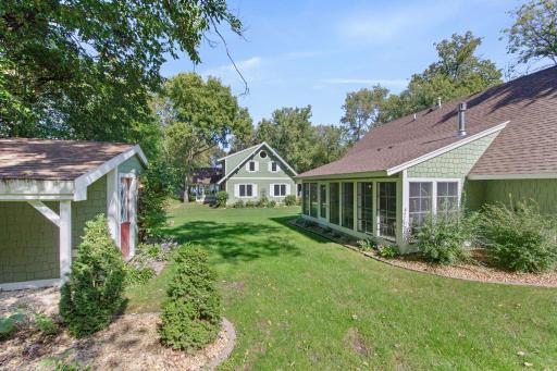 Main house south side and 3 season porch of the guest house; also game shed on the left!
