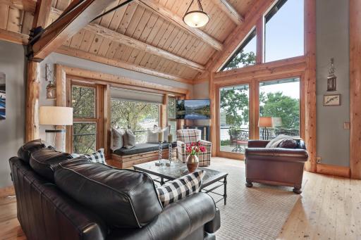 Wall of windows, soaring ceilings with exposed log beams make this home one-of-a-kind