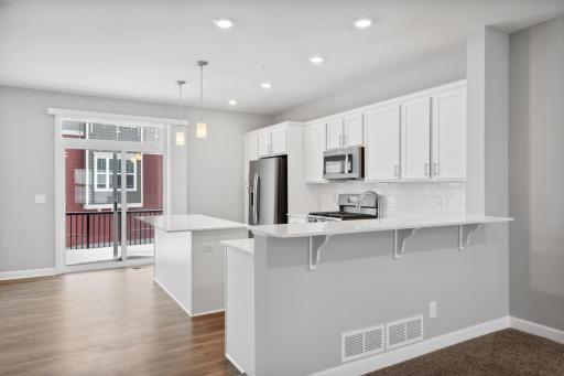 Peninsula or breakfast bar overlooking the dining and family room. Photos not of actual home. Actual home will be similar floorplan; some colors and features may vary.