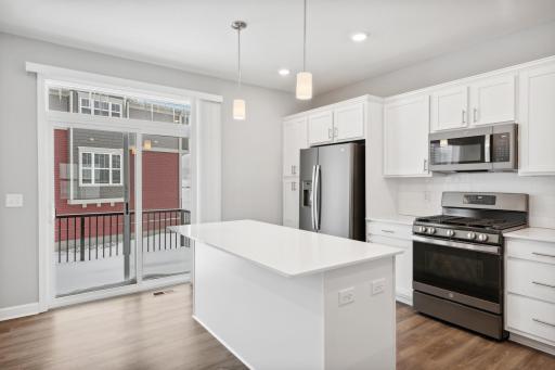 Large center island in the kitchen. This space is great for entertaining and family gatherings. Photos not of actual home. Actual home will be similar floorplan; some colors and features may vary.