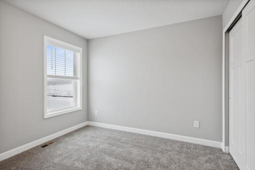 First bedroom. Photos not of actual home. Actual home will be similar floorplan; some colors and features may vary.