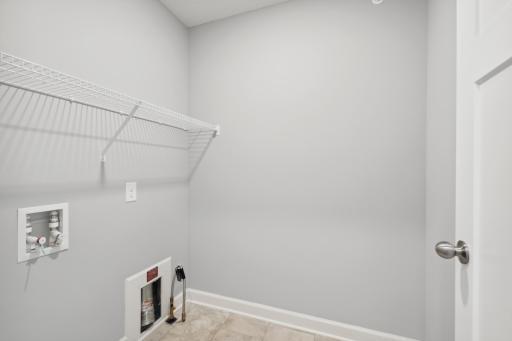 Laundry room conveniently located upstairs next to the bedrooms. Photos not of actual home. Actual home will be similar floorplan; some colors and features may vary.