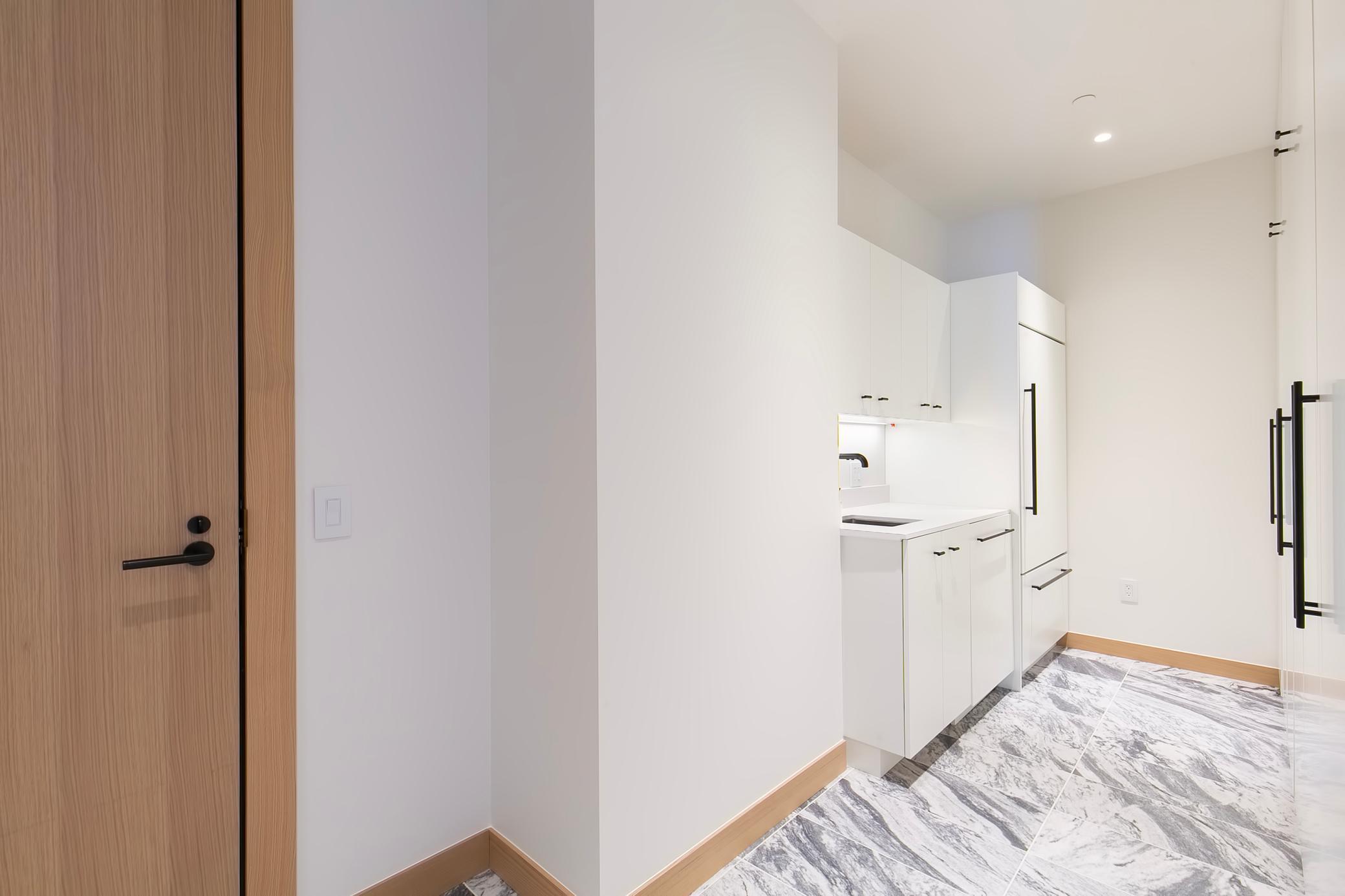 Full Laundry with locked Service door for deliveries. 2nd entrance area with additional refrigerator/freezer, sink and lots of extra storage space.