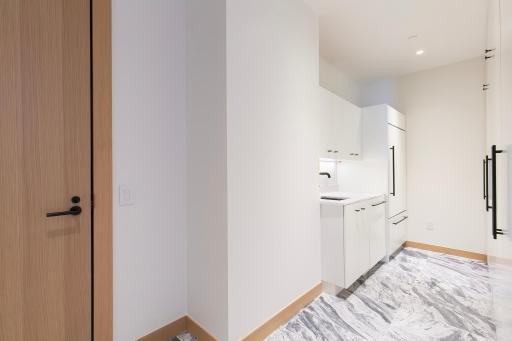 Full Laundry with locked Service door for deliveries. 2nd entrance area with additional refrigerator/freezer, sink and lots of extra storage space.