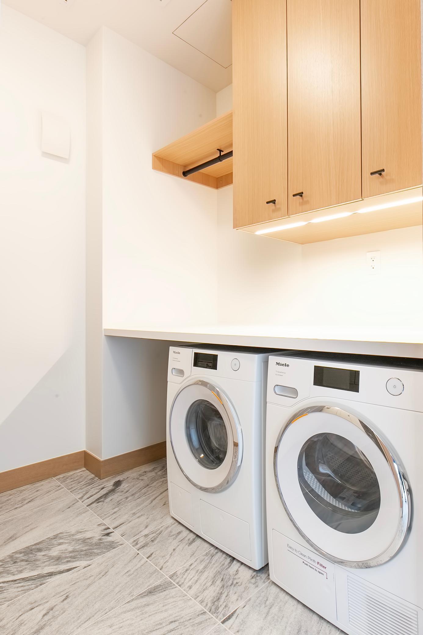 Spacious laundry room space with top-of-the-line, Miele, washer/dryer with tons of storage space.