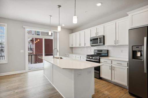Photo for 7580 38th Street N, Oakdale, MN 55128 - Listing #6338851 Large kitchen with plenty of cabinets and center island overlooking the family room or dining area. Photos are not of actual home. Actual home will be similar. Some colors and features may vary.