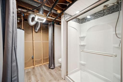 Lower level ¾ bath with storage cabinets and access to furnace and water heater (curtain shuts off view of water heater/furnace)