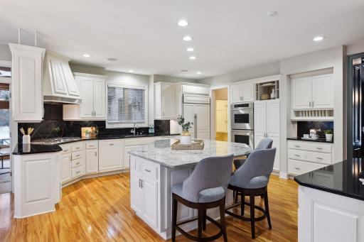 Counters next to gas range and large Thermador refrigerator allow for additional prep space