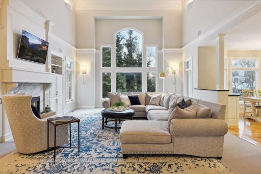 Living room offers tall ceilings and a wall of windows to a private backyard
