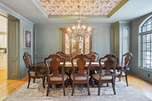 Formal dining room with lovely built-in back lit cabinet, chandelier with raised panel walls highlight the great design here