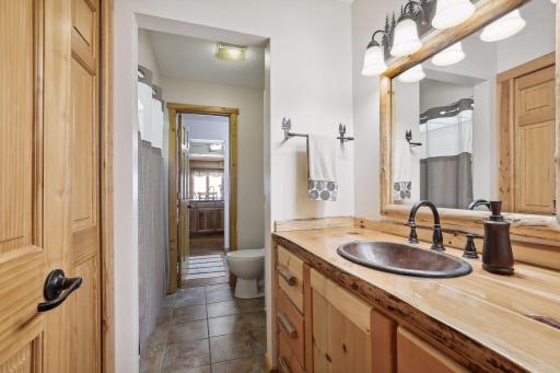 Primary walk-thru bath features copper sink and ceramic floors