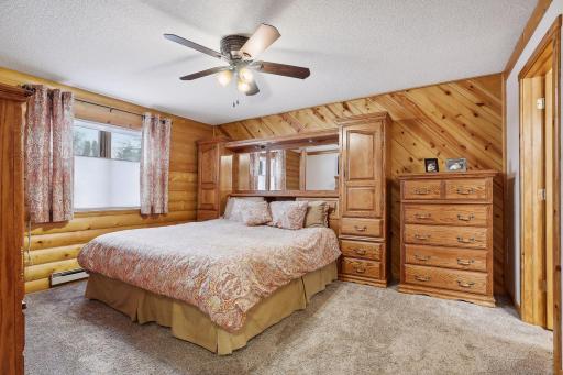 Spacious 15 x 12 primary bedroom with newer carpet and ceiling fan