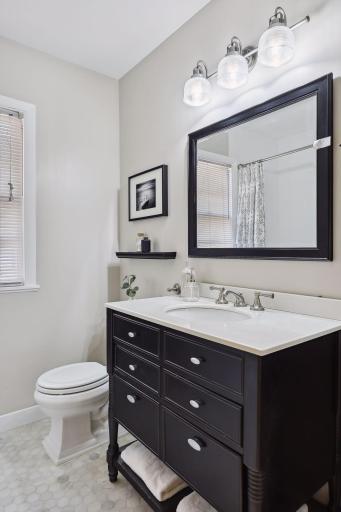 Updated main floor full bathroom with large vanity, hexagon tile flooring and subway tile shower surround.