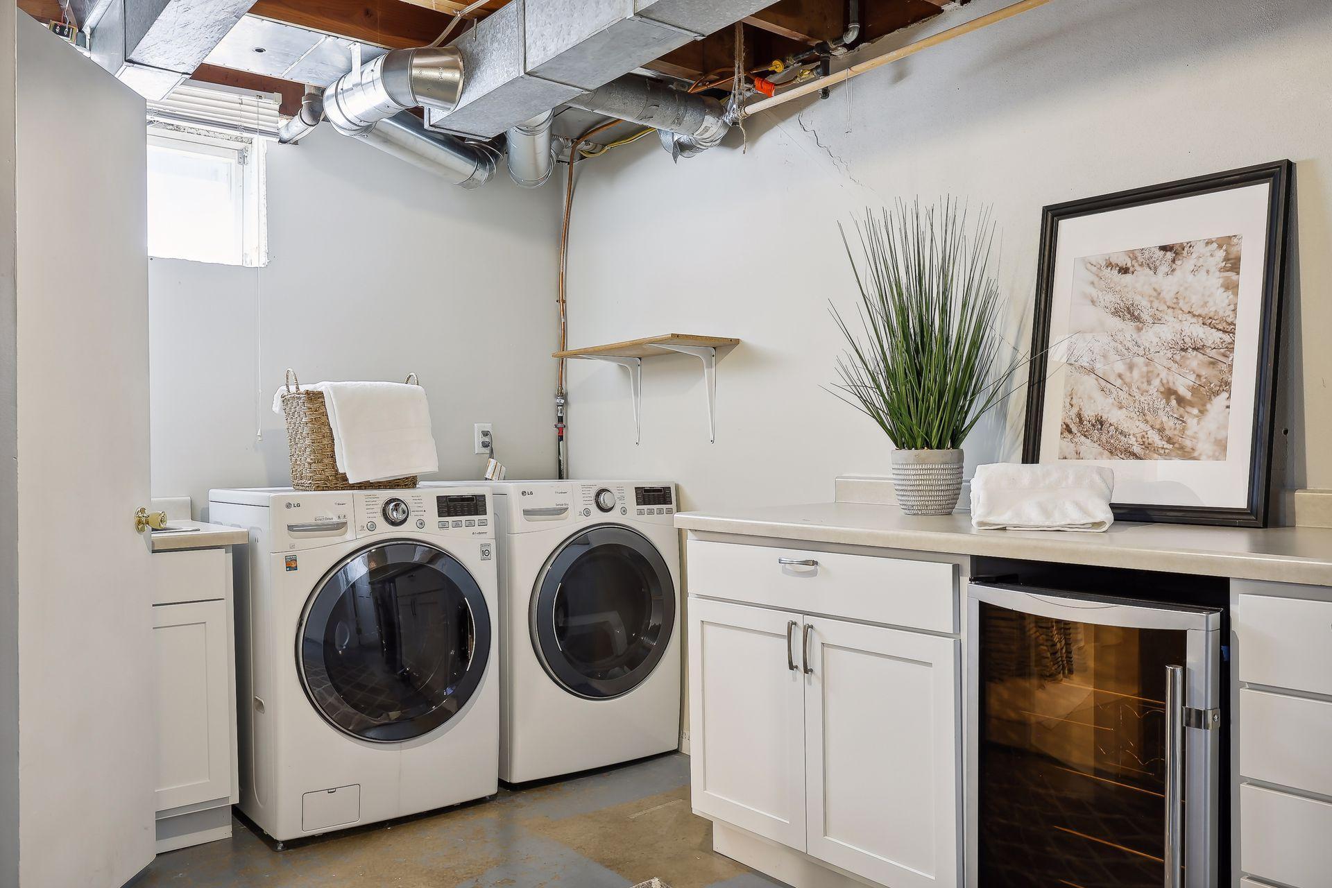 Lower level laundry room with sink, storage and countertop space.
