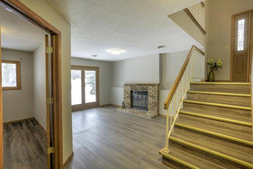 Walk out lower level family room features wood burning fireplace w/ Chicago brick surround & LVP flooring throughout.