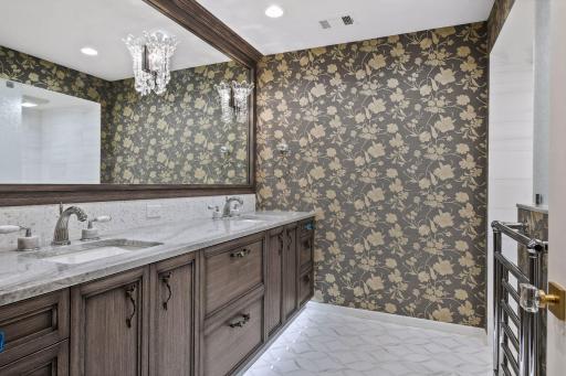 Lower level 3/4 bath features a double vanity, heated towel bar and gorgeous tile