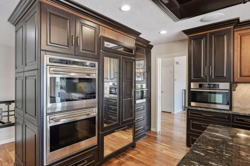Lovely high end appliances including double wall ovens, warming drawer, steam oven, microwave and check out the unique mirrored front refrigerator!