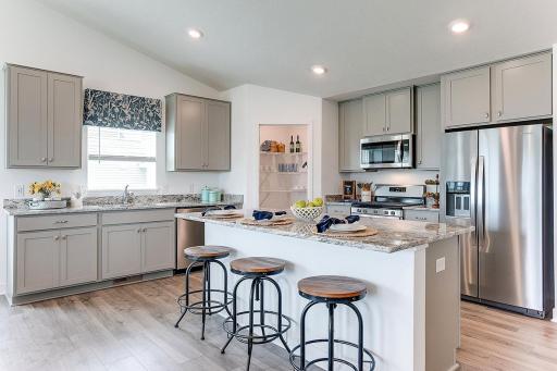 The Finnegan has a delightful kitchen with a sprawling granite island and a kitchen window over the sink. * photo of former model. * Fridge not included. See agent for colors and selections.