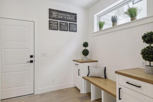 Mudroom off the garage with bench and multiple drop zones.