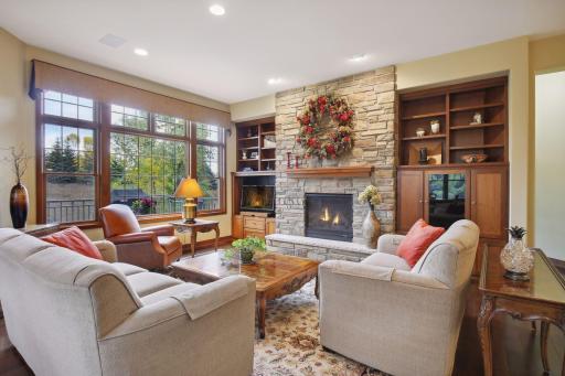 The home's casual elegance starts in the Living Room with an inviting stone fireplace, and wooded views.